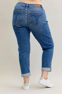 Blue jeans worn by a person on a plain background