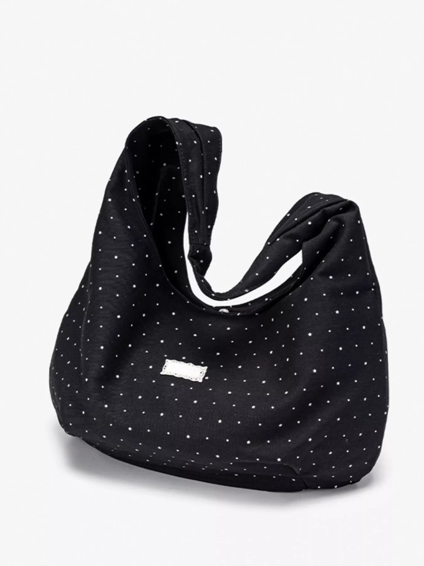 Black polka dot bag with a visible brand logo on a white background