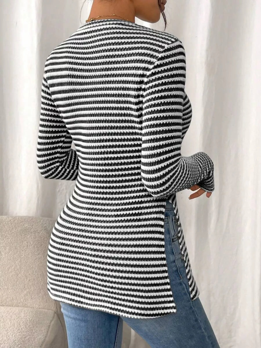 Person wearing a black and white striped sweater with a neutral background
