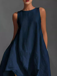 Woman wearing a blue sleeveless dress against a gray background