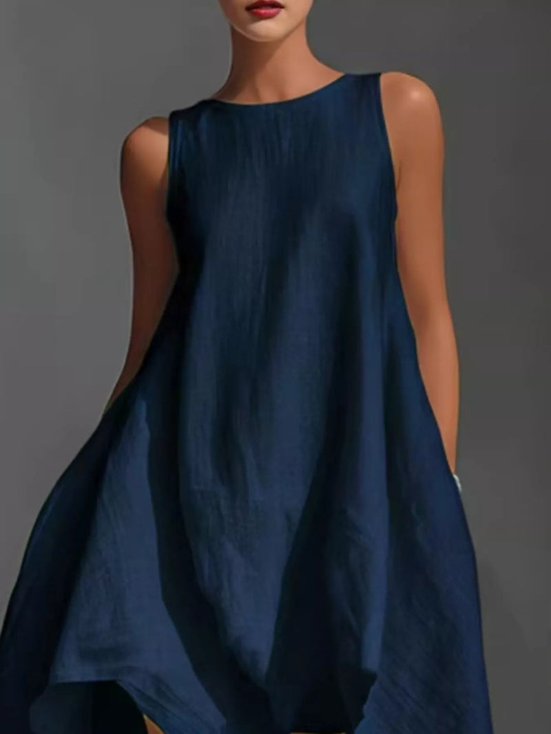 Woman wearing a blue sleeveless dress against a gray background