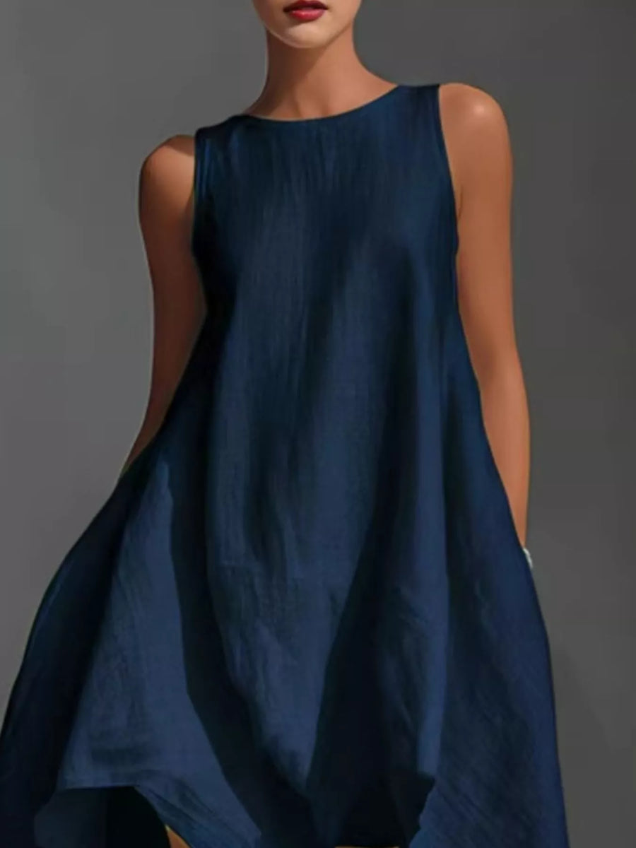 Woman wearing a blue sleeveless dress against a gray background