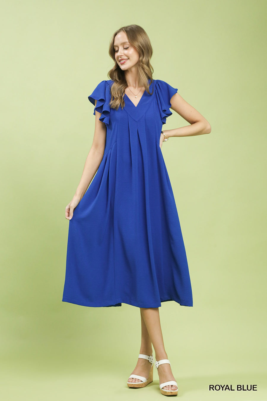 Woman wearing a blue dress on a green background