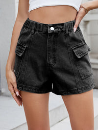 Black denim shorts worn by a person with a blurred background