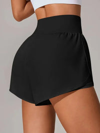 Black athletic shorts worn by a person on a plain background
