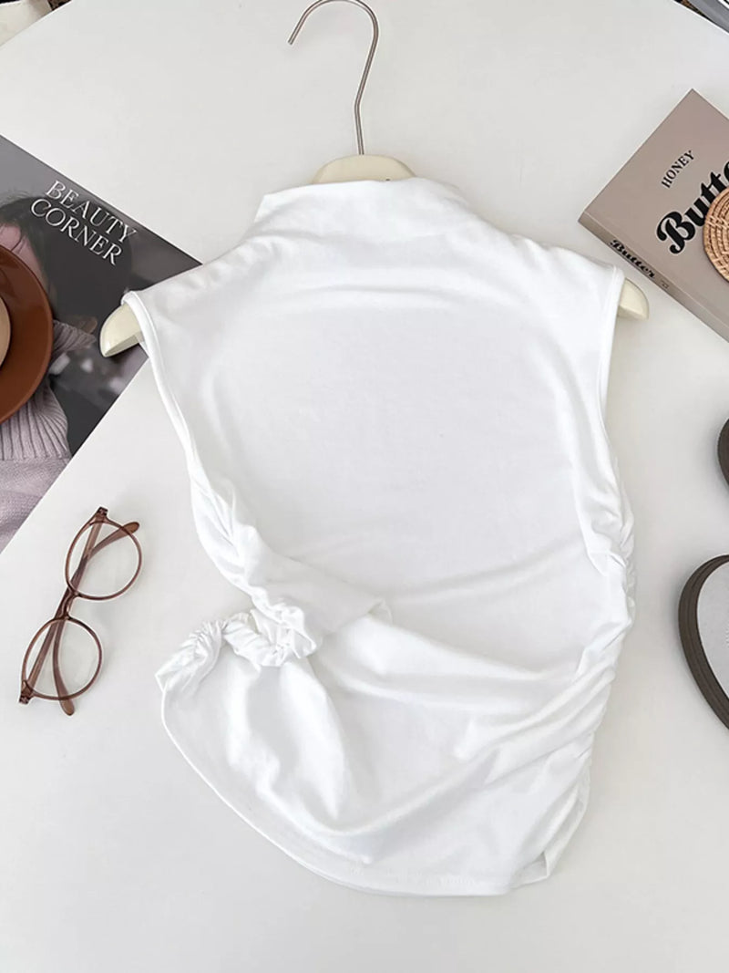 White top on a hanger with books and glasses on a table