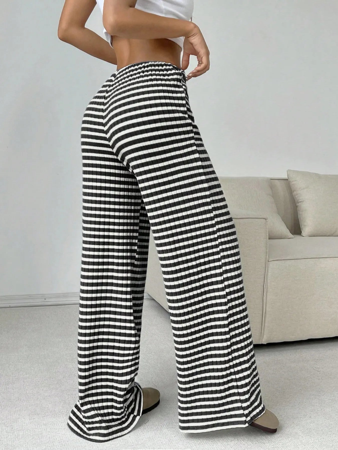 Person wearing black and white striped pants in a living room setting