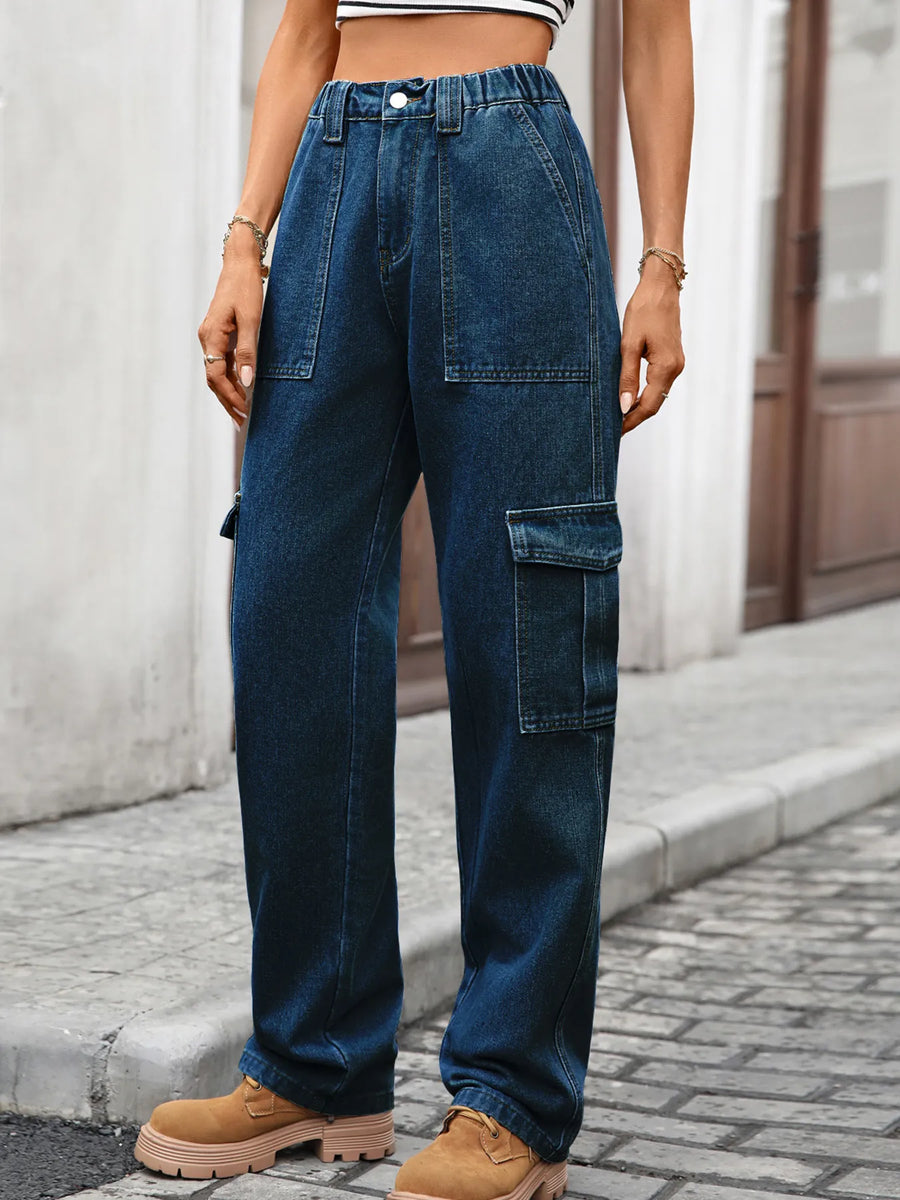 Person wearing blue jeans and brown boots on a street.