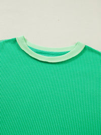 Green shirt with a light green collar on a beige background