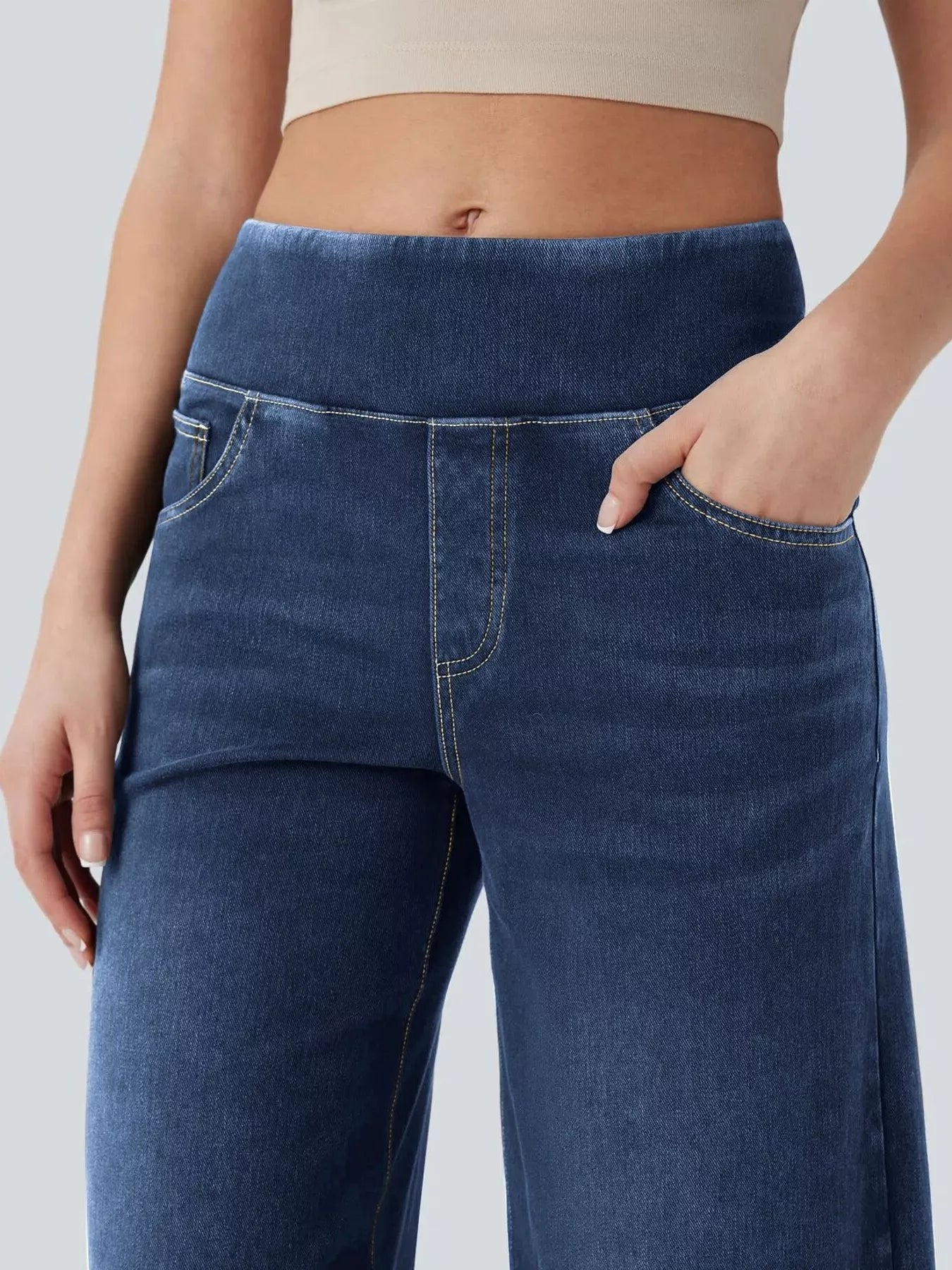 Blue jeans worn by a person on a light gray background