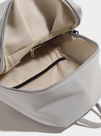 Gray backpack with open front compartment on a light gray background