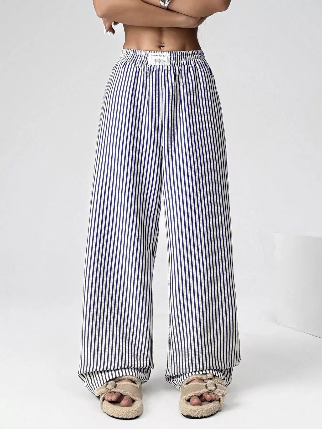 Person wearing black and white striped pants on a white background