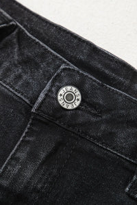 Close-up of a black denim button with 'EAM' branding on a white background