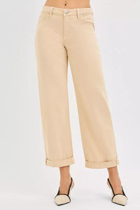 Beige pants worn by a person on a white background