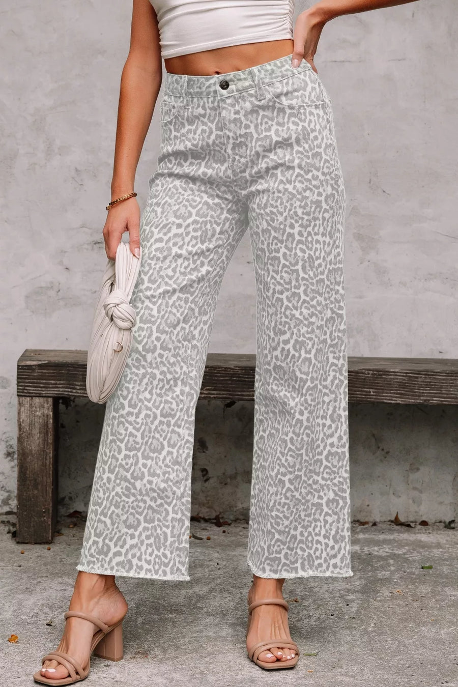 Person wearing white pants with gray leopard print pattern, standing against a plain background.