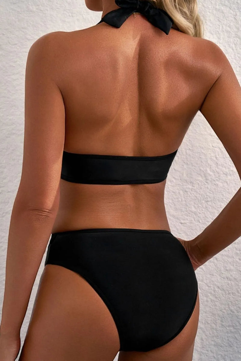 Person wearing a black bikini against a light background