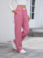 Person wearing red and white checkered pants outdoors on a stone path.