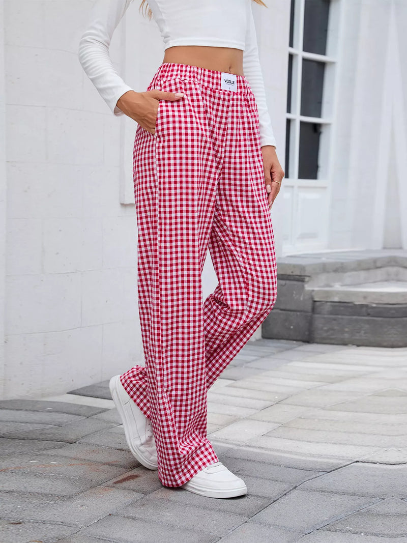 Person wearing red and white checkered pants outdoors on a stone path.