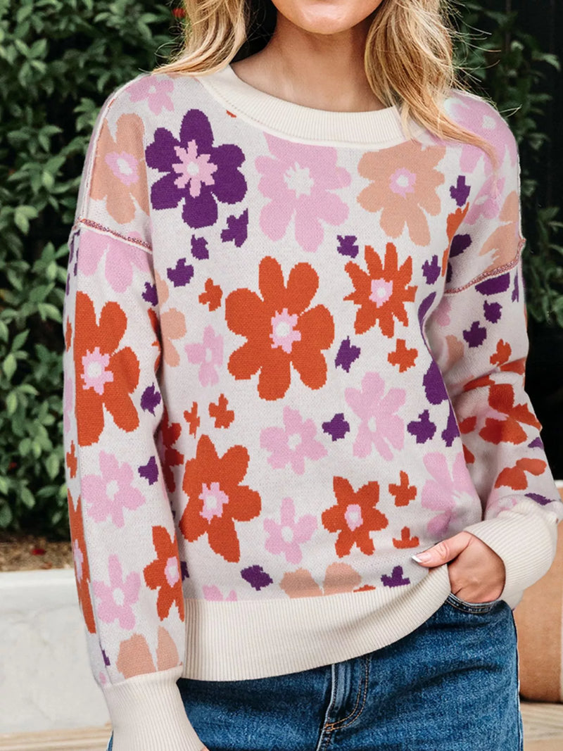 Person wearing a colorful floral sweater with a blurred background