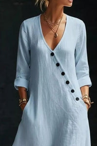 Light blue dress with black buttons on a dark background