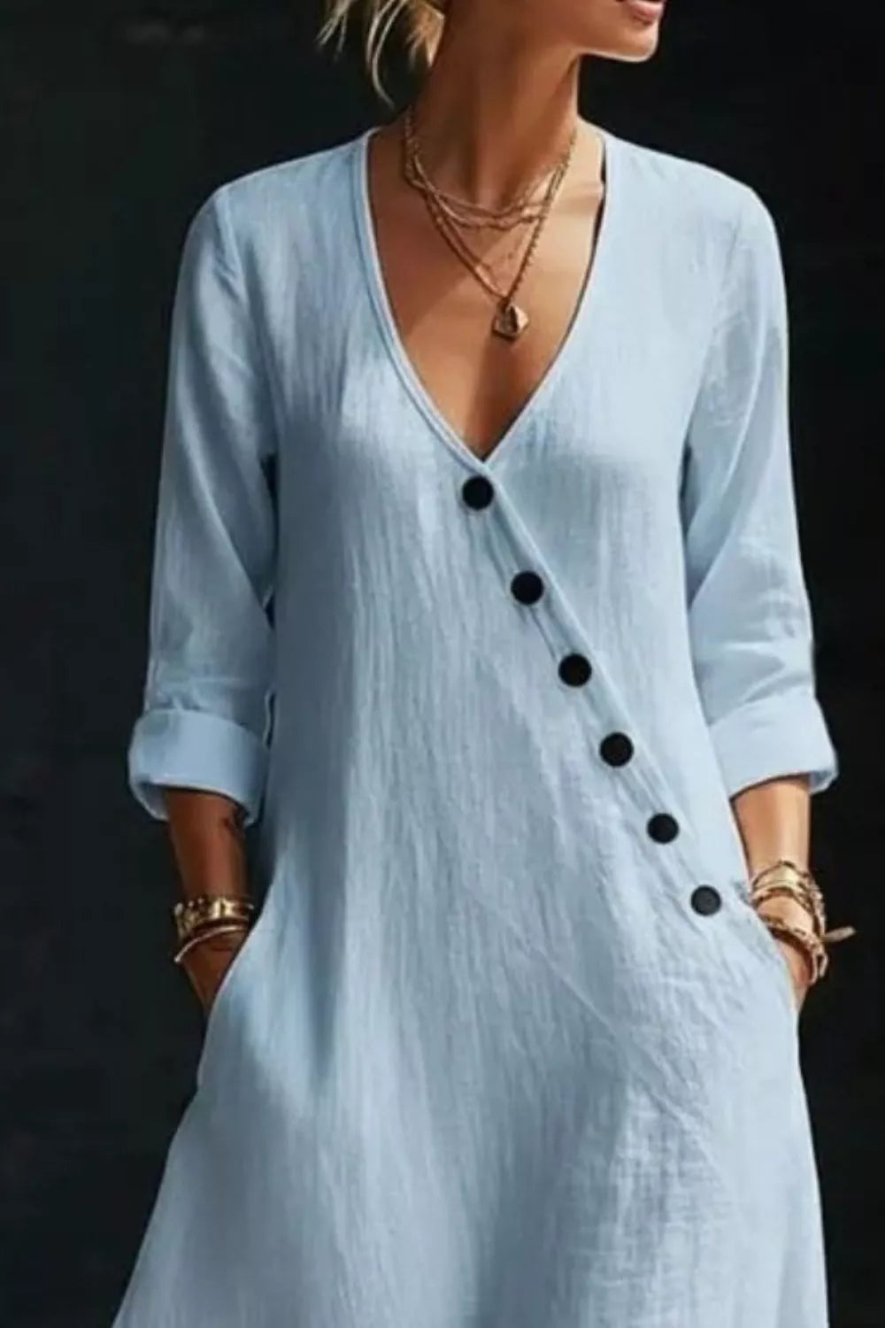 Light blue dress with black buttons on a dark background