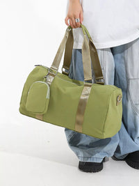 Green duffel bag with gold accents held by a person on a white background