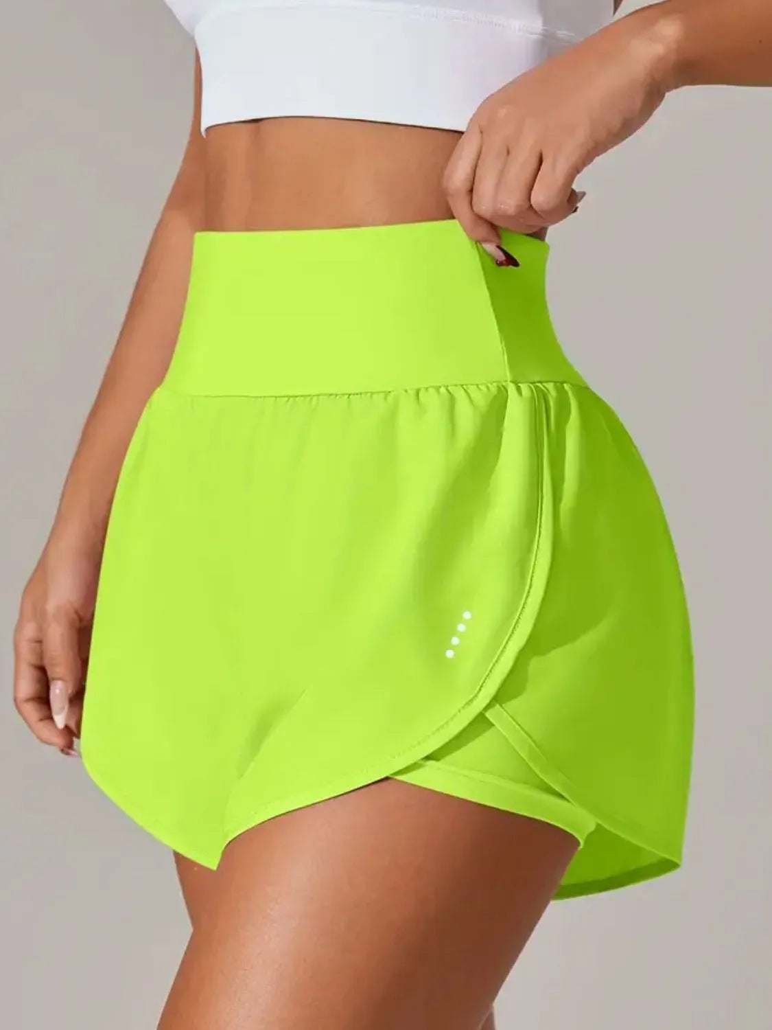 Person wearing a bright green skirt with a plain background