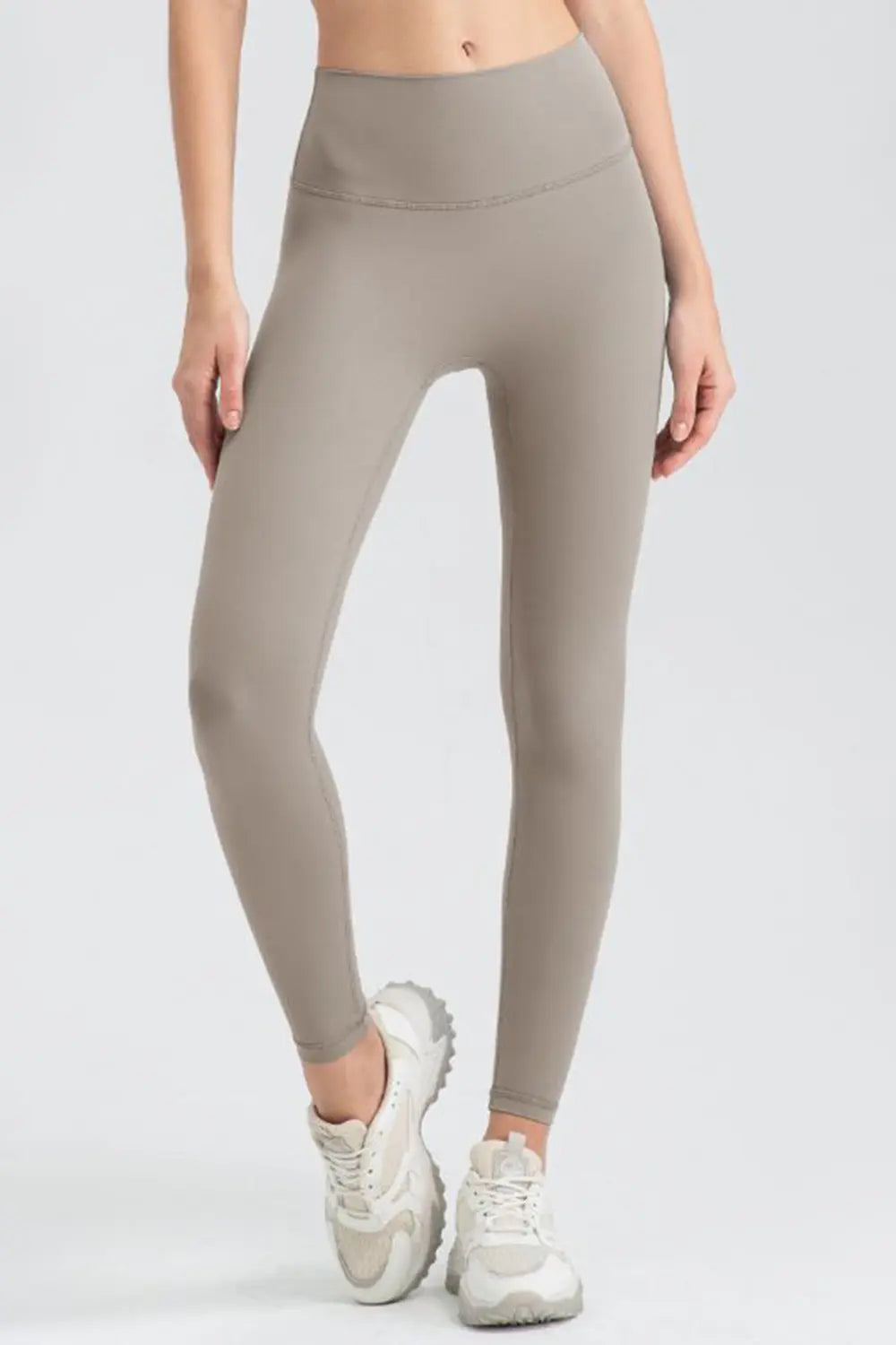 Beige leggings worn by a person on a white background