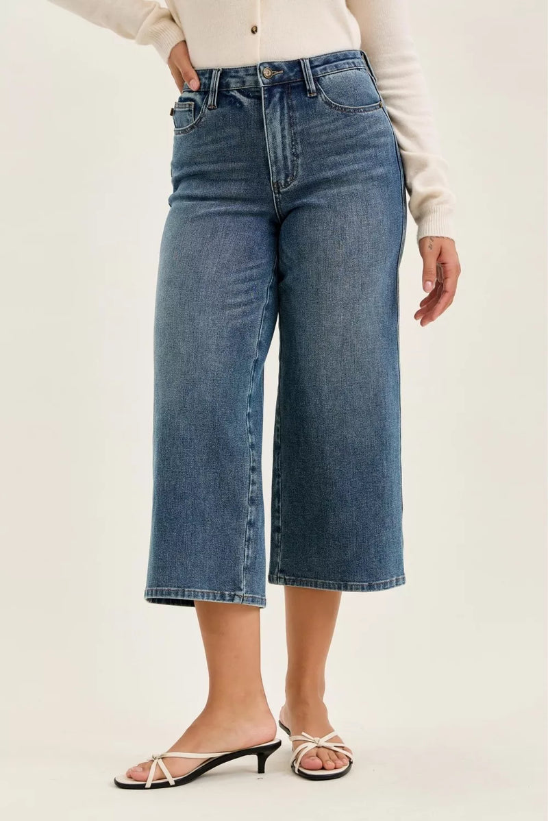 Person wearing blue jeans on a plain background