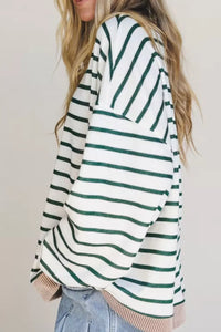 Person wearing a green and white striped sweater with a plain background