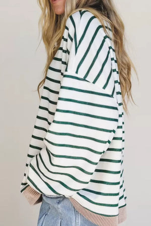 Person wearing a green and white striped sweater with a plain background