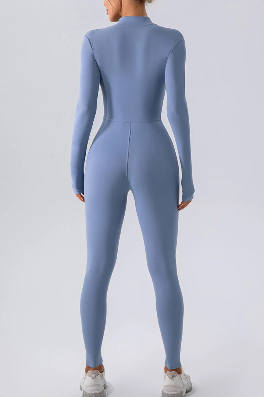 Blue jumpsuit worn by a person on a light gray background