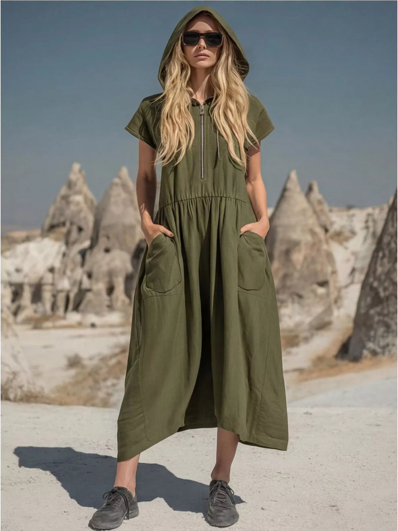 Woman wearing a green hooded dress with rock formations in the background