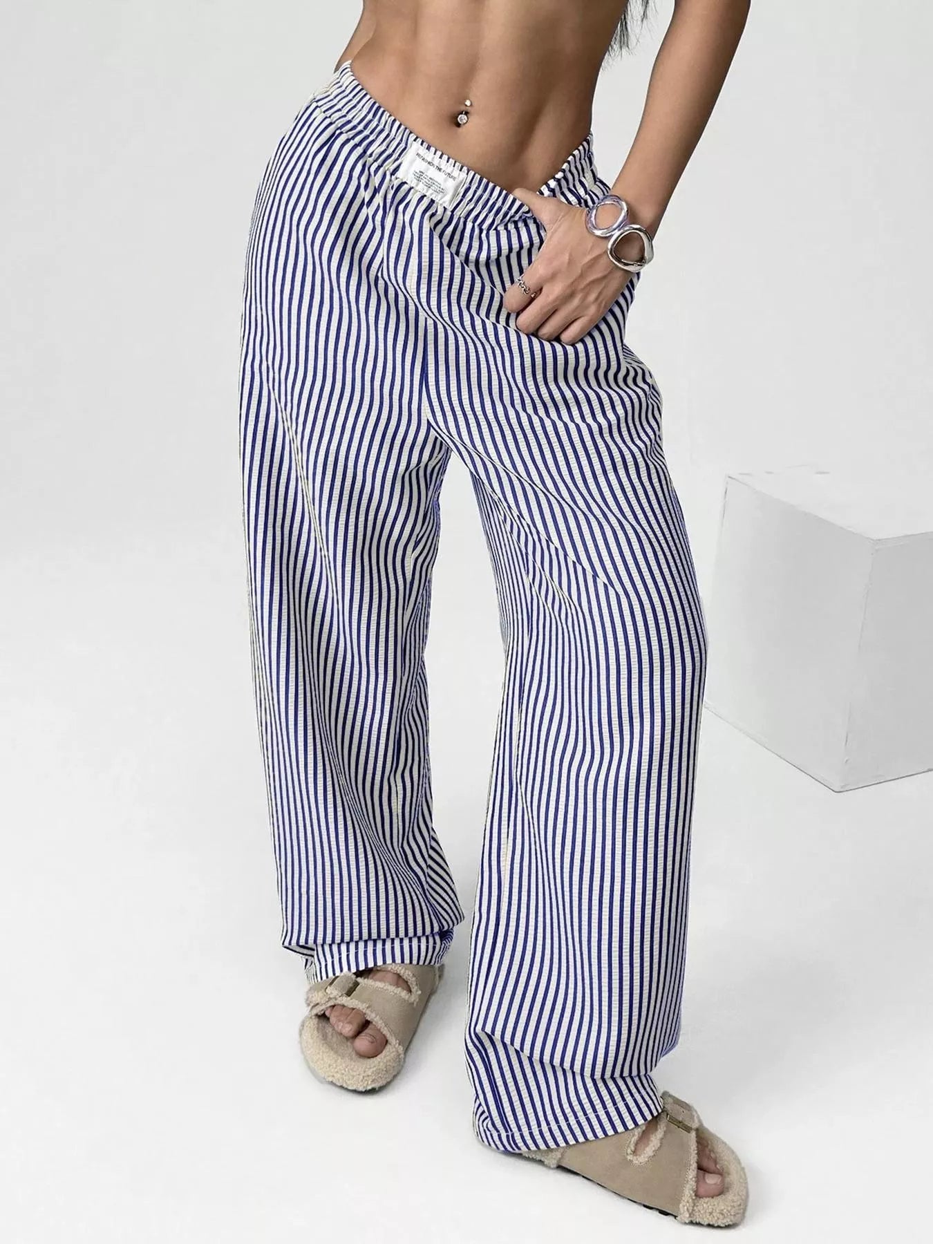 Person wearing blue and white striped pants on a white background