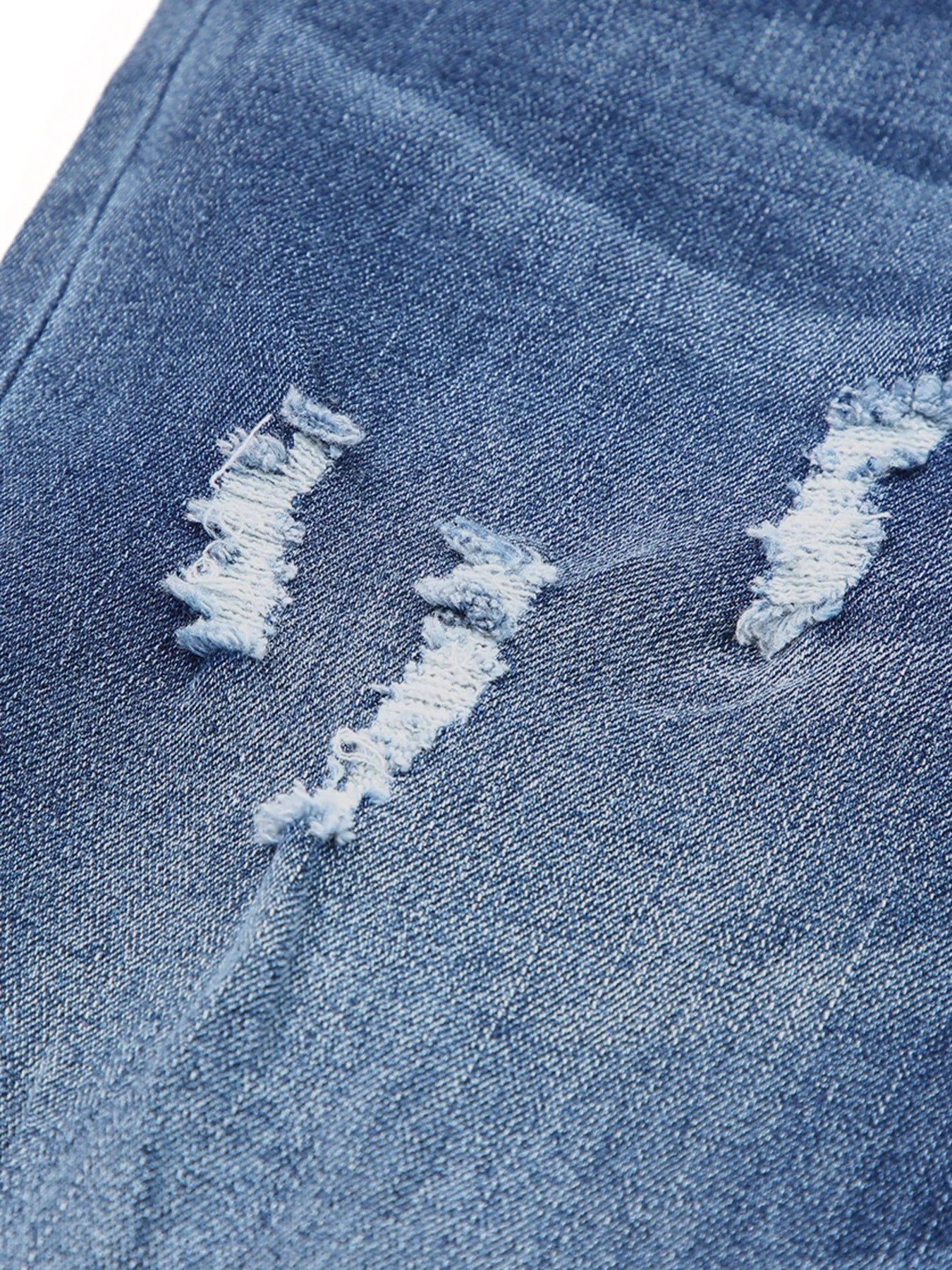 Close-up of distressed blue denim fabric