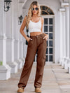 Woman wearing a white crop top and brown cargo pants standing on a porch.