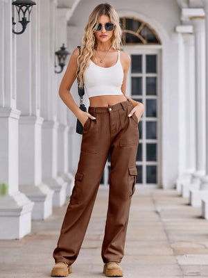 Woman wearing a white crop top and brown cargo pants standing on a porch.
