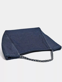 Blue denim bag with a chain detail on a light gray background