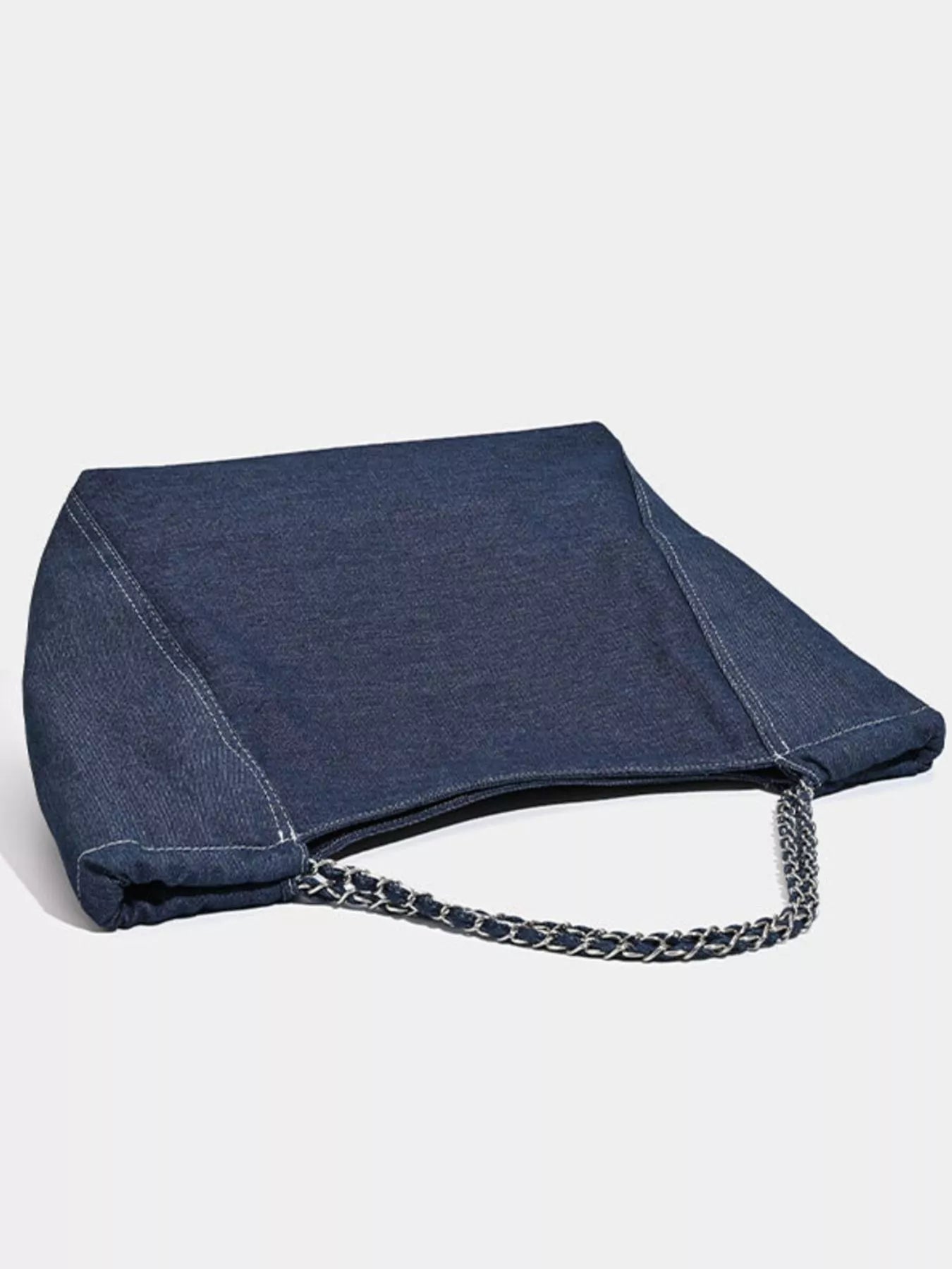 Blue denim bag with a chain detail on a light gray background
