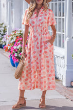 Woman wearing a pink polka dot dress with a straw bag on a sunny day.