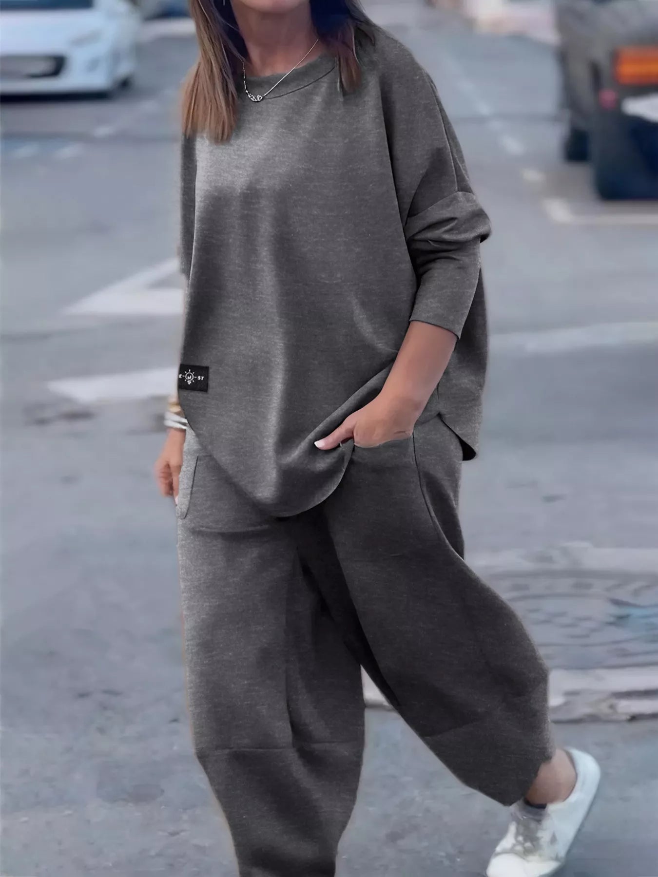 Person wearing a gray outfit on a street background