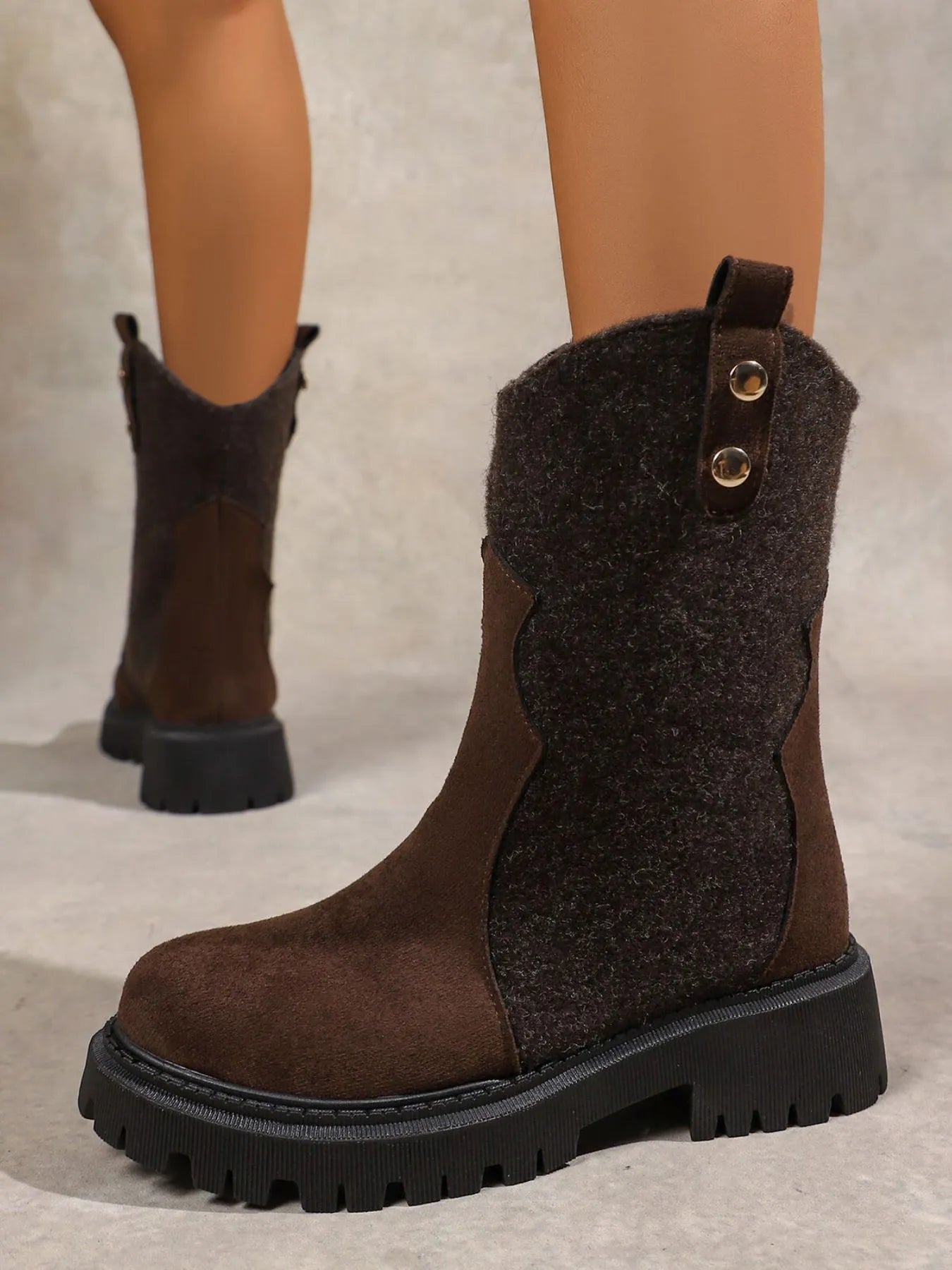 Brown knee-high boots with a textured finish on a neutral background