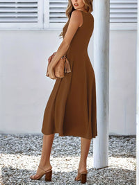 Woman wearing a brown dress holding a matching clutch against a white background