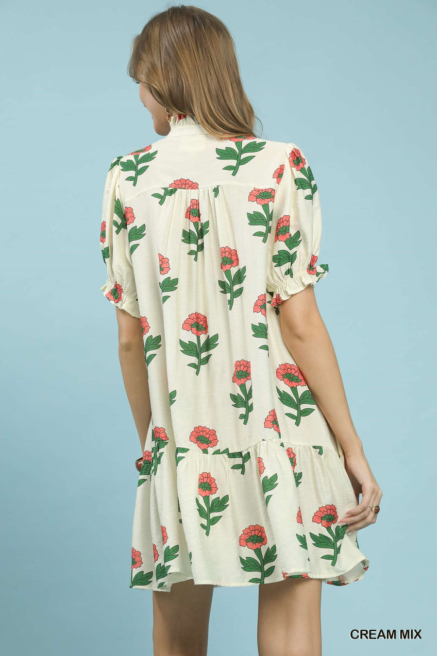 Woman wearing a floral dress with a cream background
