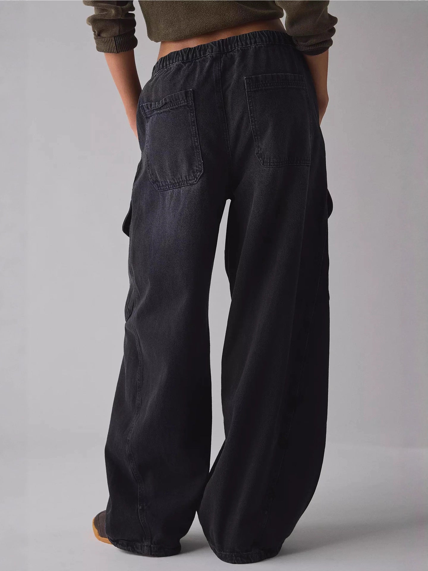 Person wearing wide-leg black pants on a plain background