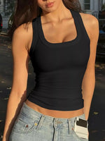 Person wearing a black tank top and light blue jeans outdoors