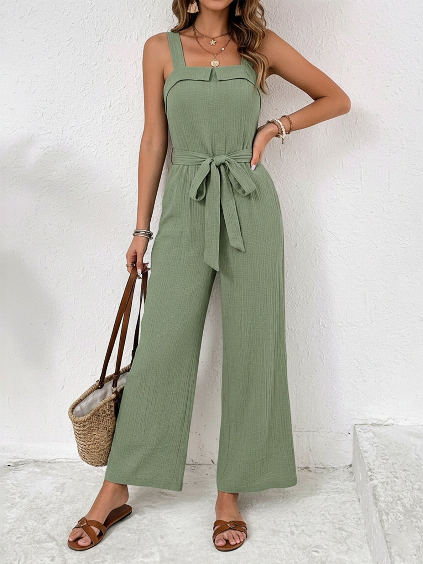 Woman wearing a green jumpsuit with a white background