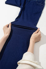 Person holding a blue fabric against a white background