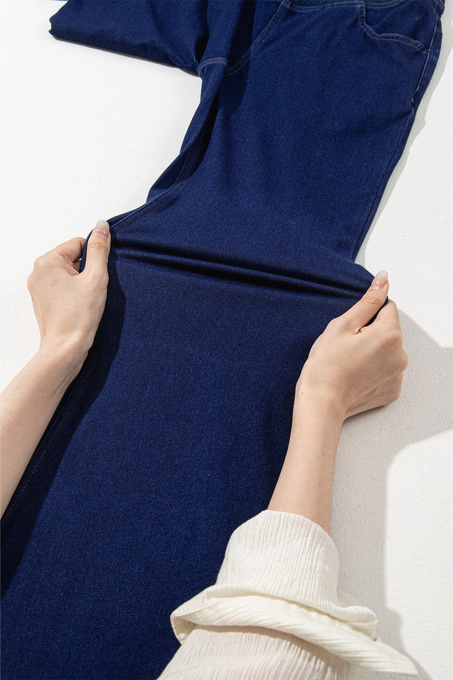 Person holding a blue fabric against a white background