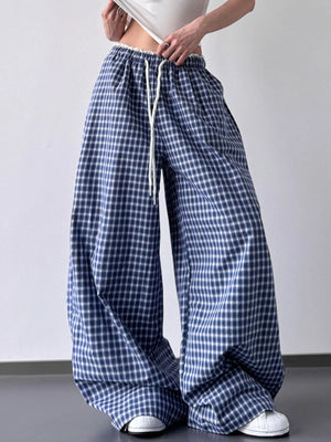 Blue and white checkered pants worn by a person on a plain background
